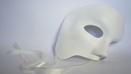 Masque de visage blanc posé sur un fond blanc