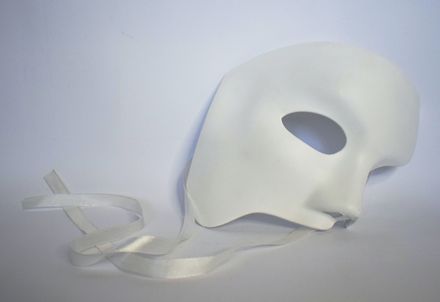 Masque de visage blanc posé sur un fond blanc