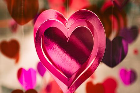Coeur rose en carton brillant suspendu contenant plusieurs coeurs