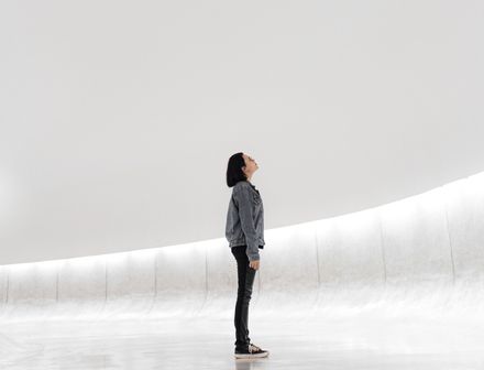 Jeune femme à lunettes dans un espace vide et blanc regardant vers le haut