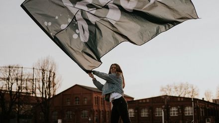 Jeune femme brandissant fièrement un drapeau où il est écrit "Jésus"