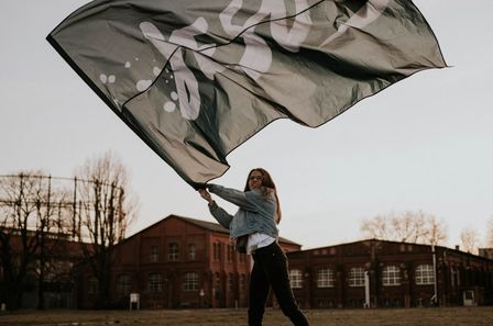 Jeune femme brandissant fièrement un drapeau où il est écrit "Jésus"