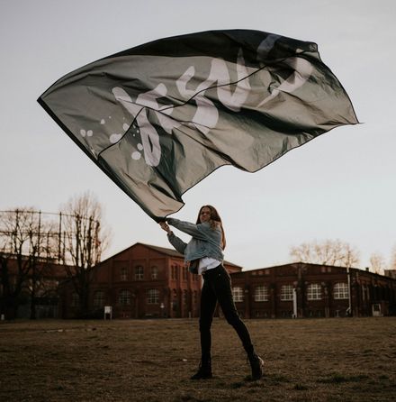 Jeune femme brandissant fièrement un drapeau où il est écrit "Jésus"