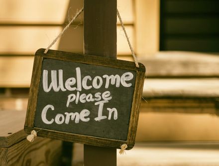 Ardoise avec cadre en bois sur lequel il est écrit -Welcome please come in-