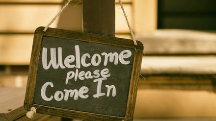 Ardoise avec cadre en bois sur lequel il est écrit -Welcome please come in-
