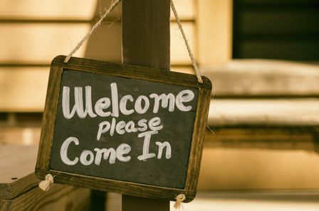 Ardoise avec cadre en bois sur lequel il est écrit -Welcome please come in-