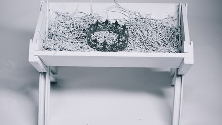 Mangeoir à foin blanche contenant une couronne en argent