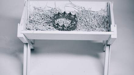 Mangeoir à foin blanche contenant une couronne en argent