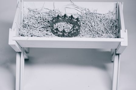 Mangeoir à foin blanche contenant une couronne en argent
