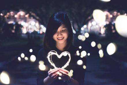 Jeune femme tenant un coeur lumineux