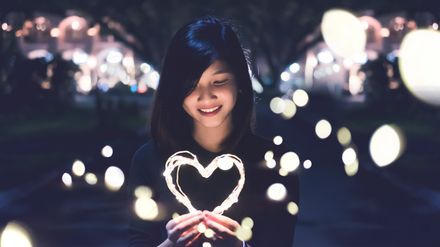 Jeune femme tenant un coeur lumineux