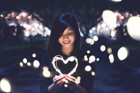 Jeune femme tenant un coeur lumineux
