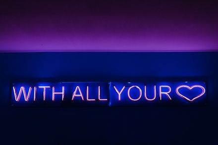 Panneau néon lumineux où il est écrit "with all your heart"