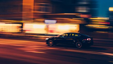 Voiture filant à toute vitesse dans la nuit en ville