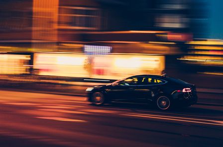 Voiture filant à toute vitesse dans la nuit en ville