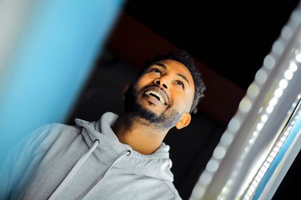 Homme en sweat à capuche gris regardant vers le haut en souriant