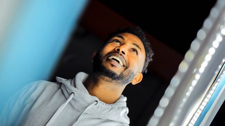 Homme en sweat à capuche gris regardant vers le haut en souriant
