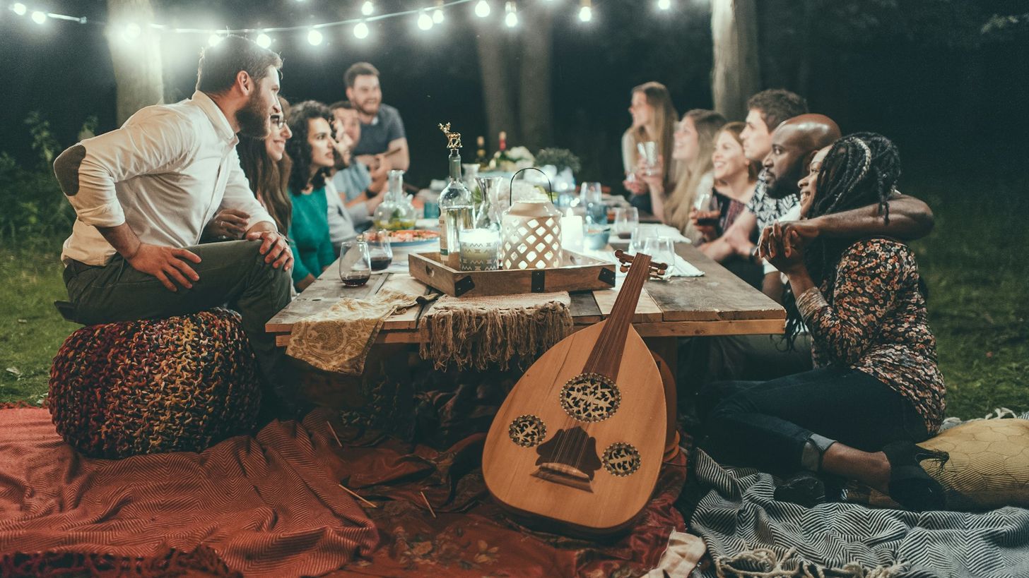 Tablée d'amis discutant autour d'un repas du soir
