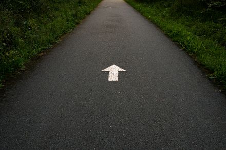 Flèche blanche peinte sur une route.
