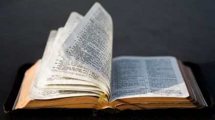 Bible ouverte dont les pages se tournent sous l'effet du vent