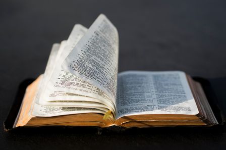 Bible ouverte dont les pages se tournent sous l'effet du vent