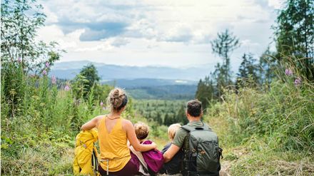 Famille qui regarde une vallée, prête à l'aventure