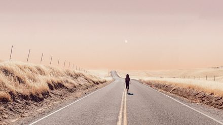 Femme marchant sur une route en bord de mer dans une paisible atmosphère