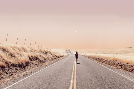 Femme marchant sur une route en bord de mer dans une paisible atmosphère