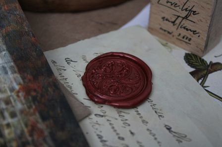 Un sceau de cire rouge posé sur un morceau de papier ancien