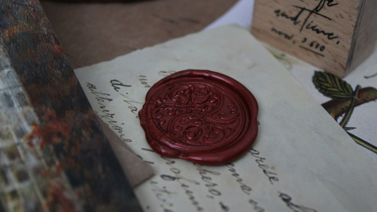 Un sceau de cire rouge posé sur un morceau de papier ancien